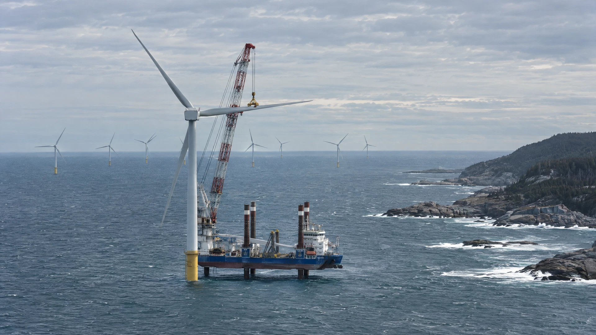 AI-generated concept of a wind-turbine installation vessel off Canada's Atlantic coast, near a rocky evergreen headland.